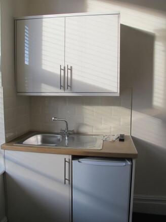 Compact kitchenette with sink and bright cabine...