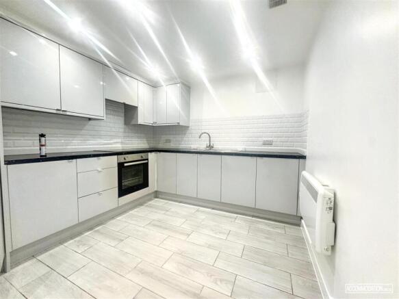 Bright, modern kitchen with sleek white cabinet...