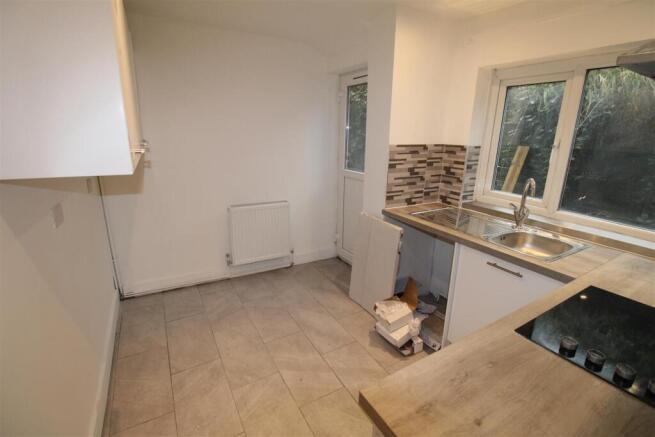 Bright kitchen with modern tiling and workspace...