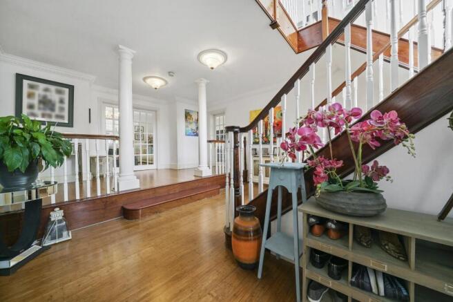 Grand entrance hall with elegant wooden stairca...