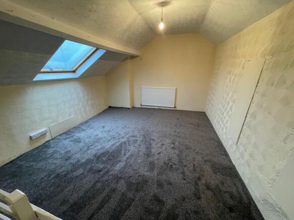 Bright attic room with plush dark grey carpet...