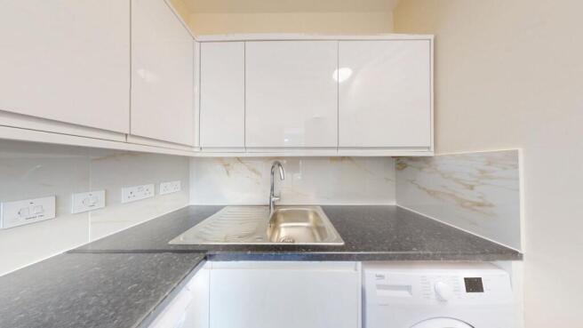 Modern compact kitchen with sleek white cabinet...