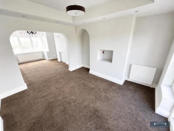 Spacious open-plan living room with natural lig...