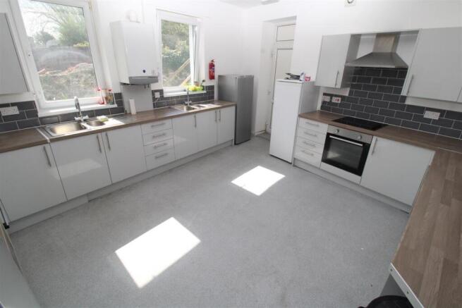 Spacious modern kitchen with sleek white cabine...
