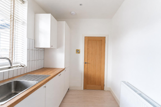 Minimalist White Kitchen with Wood Accents.png