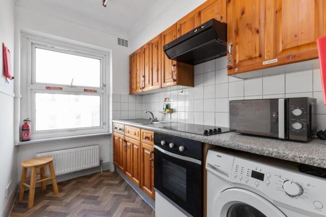 Bright kitchen with wooden cabinets and applian...
