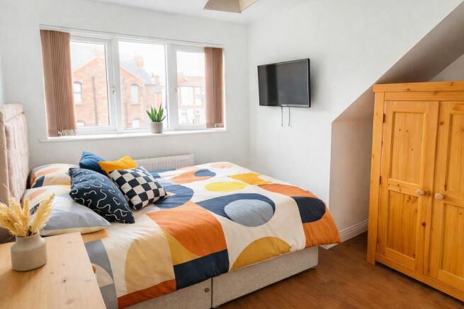 Bright double room with colourful bedding and T...
