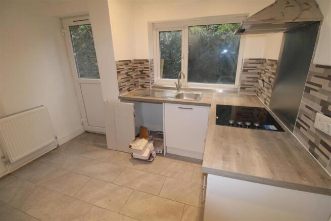 Bright kitchen with modern tiling and garden ac...