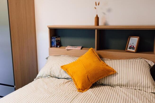 Bright, neatly presented bedroom with a cozy do...