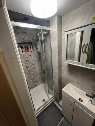 Modern tiled shower room with mirrored storage...