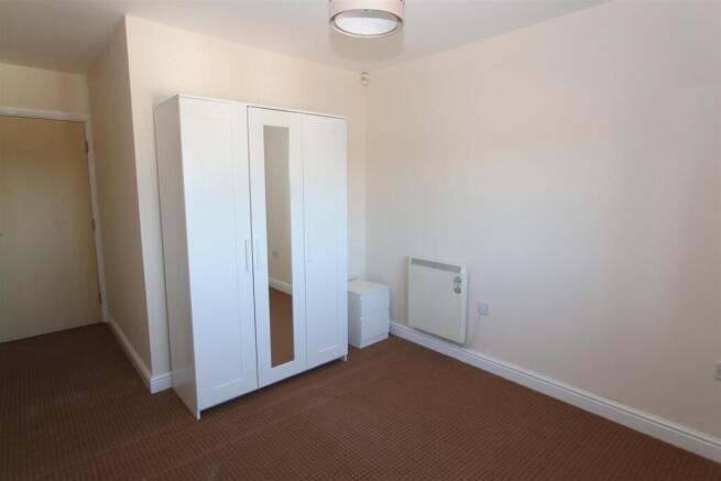 Bright bedroom with sleek mirrored wardrobe...