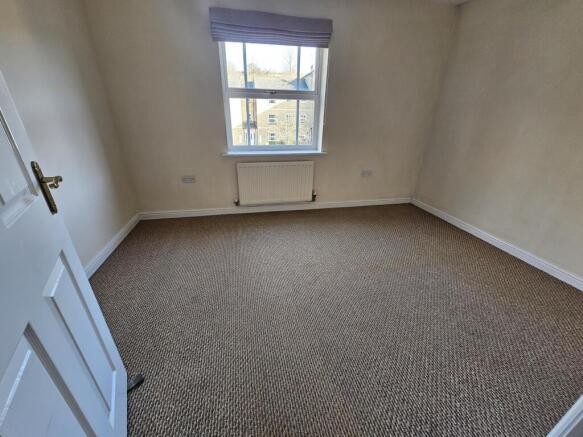 Bright, neutral bedroom with a large window, ne...