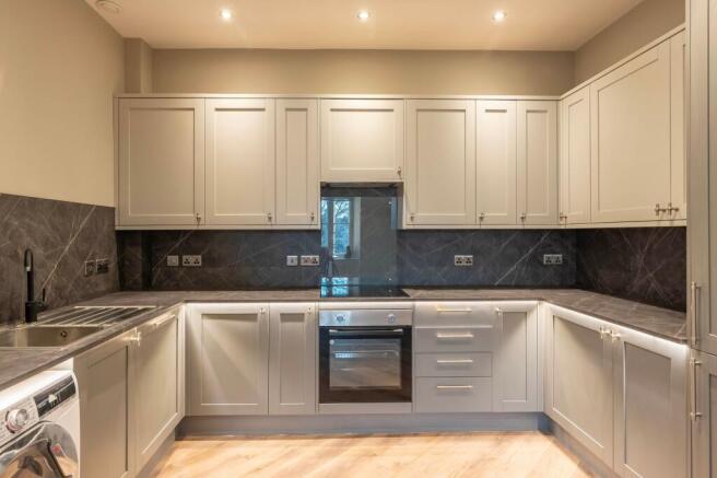 Modern U-shaped kitchen with grey shaker cabine...