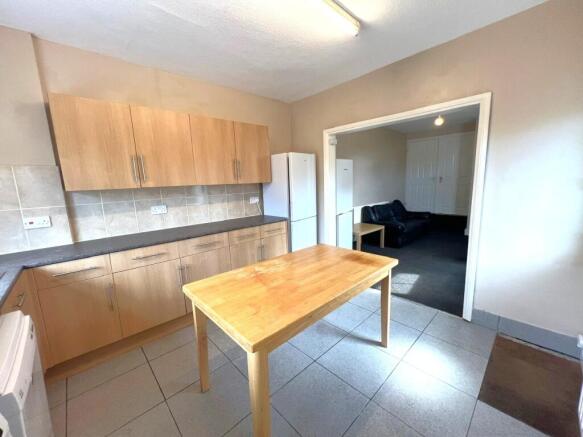 Bright kitchen with light wood cabinets, tiled ...