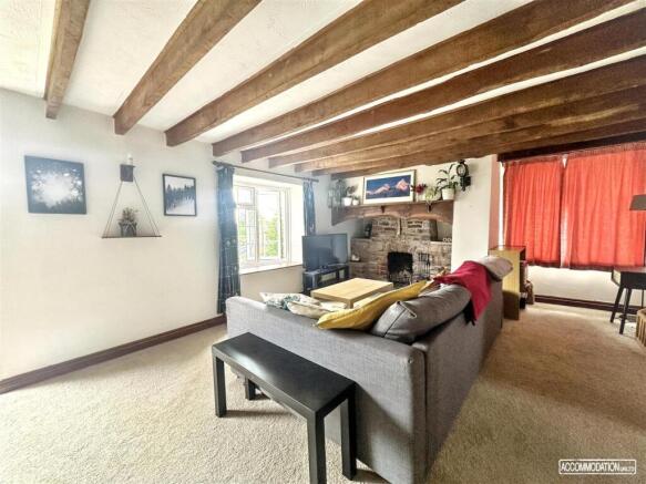 Charming living room with rustic wooden beams...