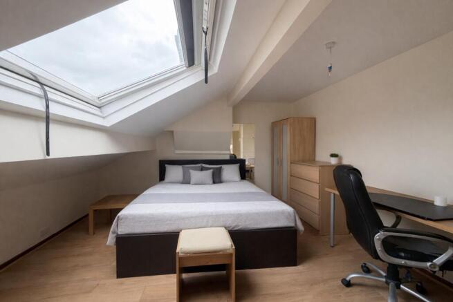 Bright bedroom with large skylight and desk....