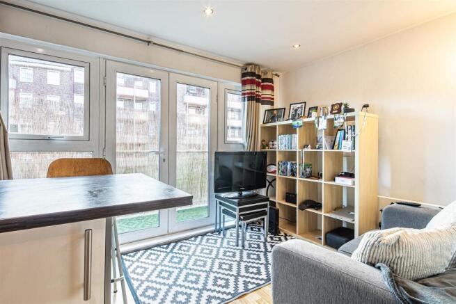 Bright lounge with large doors and modern rug...