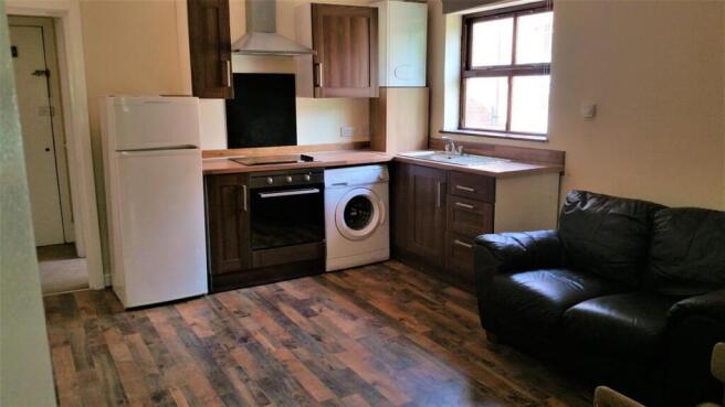 Bright open-plan kitchen area with fitted units...