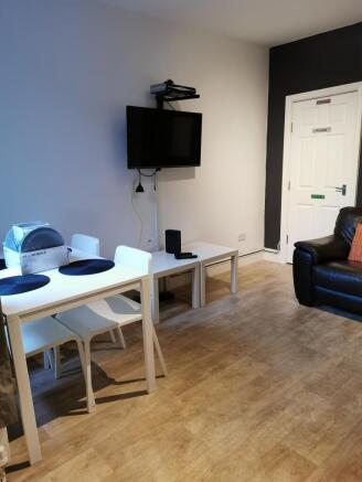 Bright, modern living area with wood-effect flo...