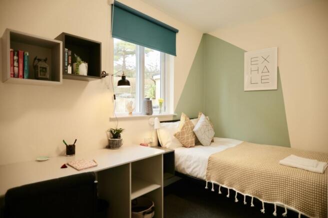 This cozy double bedroom features a comfortable...