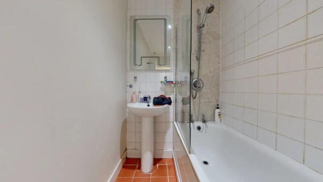A clean and functional bathroom featuring a whi...