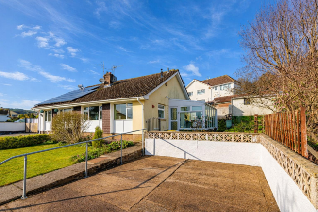 Sunlit bungalow with scenic driveway.png