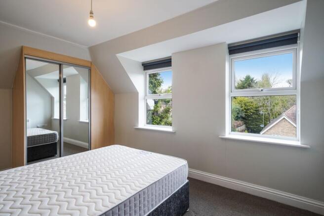 Bright double bedroom with mirrored wardrobes a...