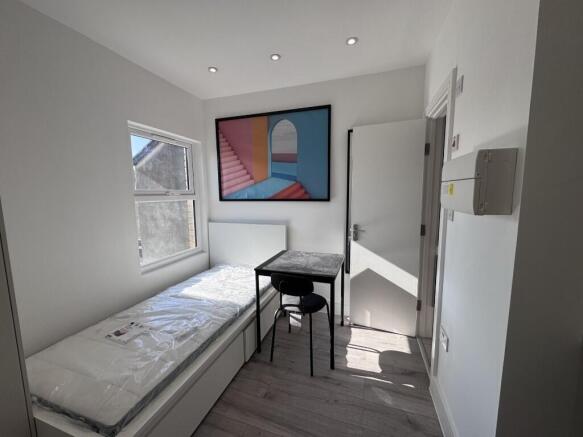 Bright, simply furnished single bedroom with a ...