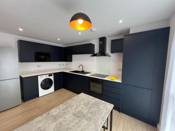 Modern L-shaped kitchen with dark matte cabinet...