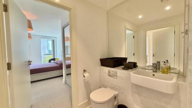 Modern en-suite bathroom with large mirror...