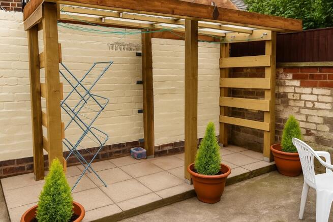 Private paved patio with a sheltered pergola...
