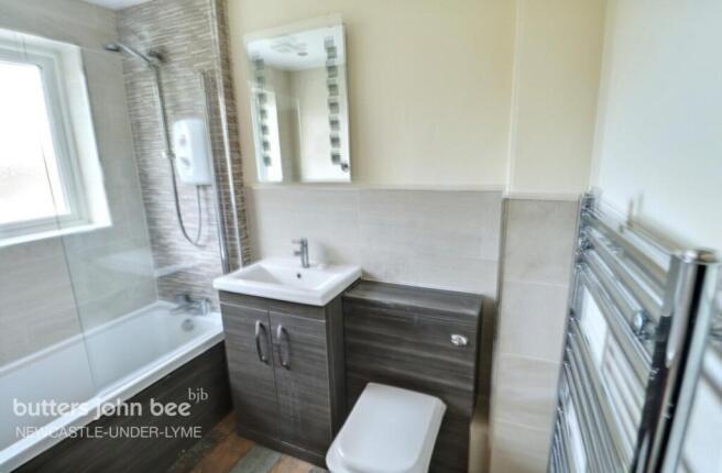 Modern bathroom with shower-over-bath and vanit...