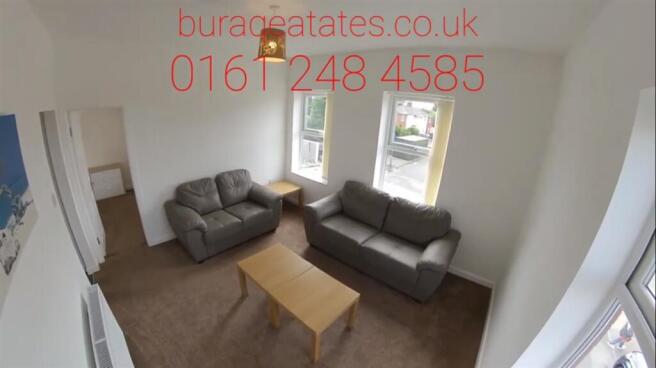 Bright, well-lit living room with two grey sofa...