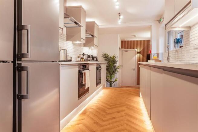 Modern kitchen with sleek units and floor light...