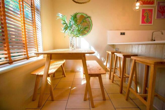 Bright kitchen with wooden seating and sunny ba...