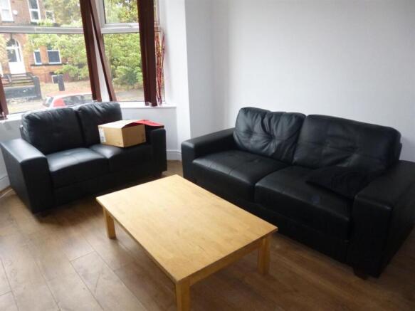 Bright living room with large windows, two blac...