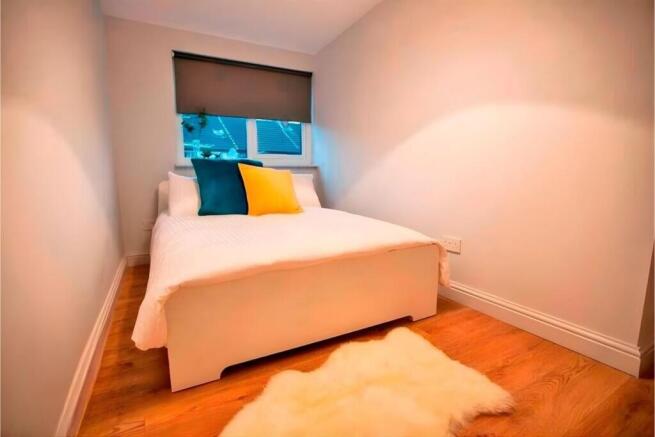 Cosy double bedroom with bright accent cushions...