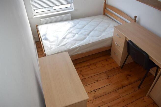 Compact, clean bedroom with a single bed, woode...