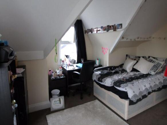 A cozy bedroom with a double bed, stylish beddi...