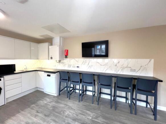 Bright, modern communal kitchen with a long bre...