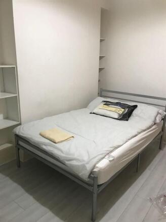 Simple, tidy double bedroom with a metal-frame ...