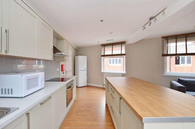 Bright, modern kitchen with a large central isl...