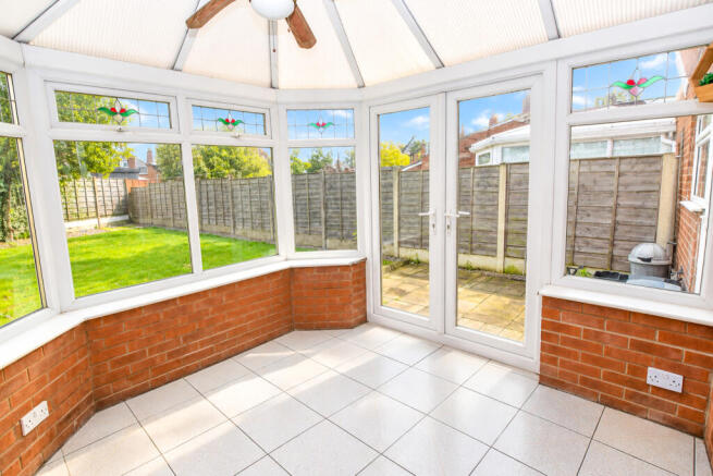 Sunlit Empty Conservatory Overlooking Garden