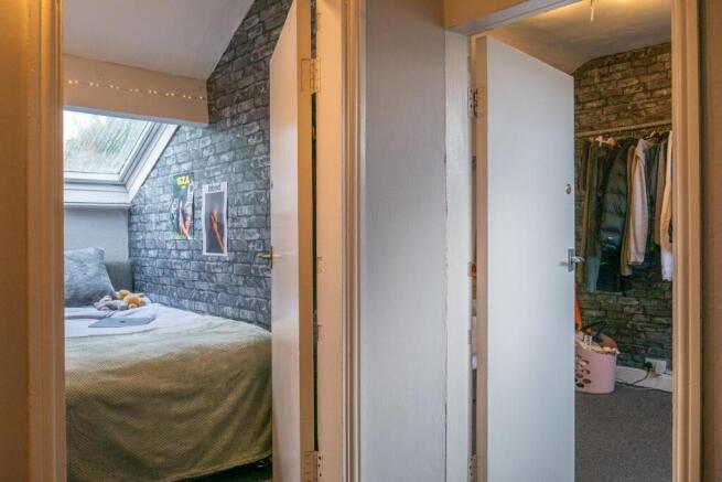 A well-lit master bedroom featuring a comfortab...