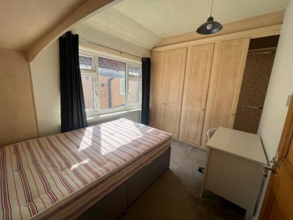 Bright single bedroom with a large window letti...