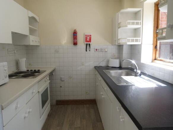 Bright galley kitchen with a window providing n...