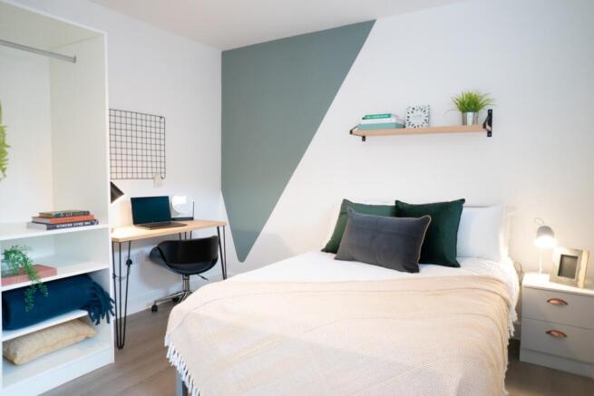 A bright and inviting double bedroom with styli...