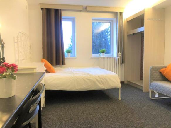 Bright and cozy double bedroom featuring two la...