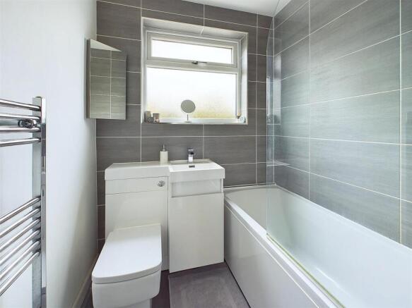 Bright modern bathroom with grey tiled walls, w...
