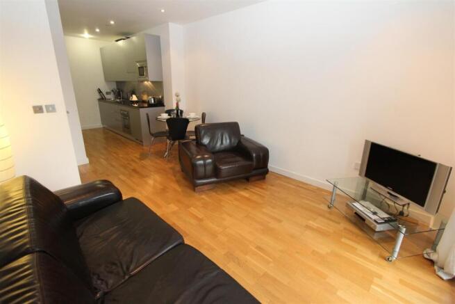 Bright open-plan lounge with sleek wood floorin...
